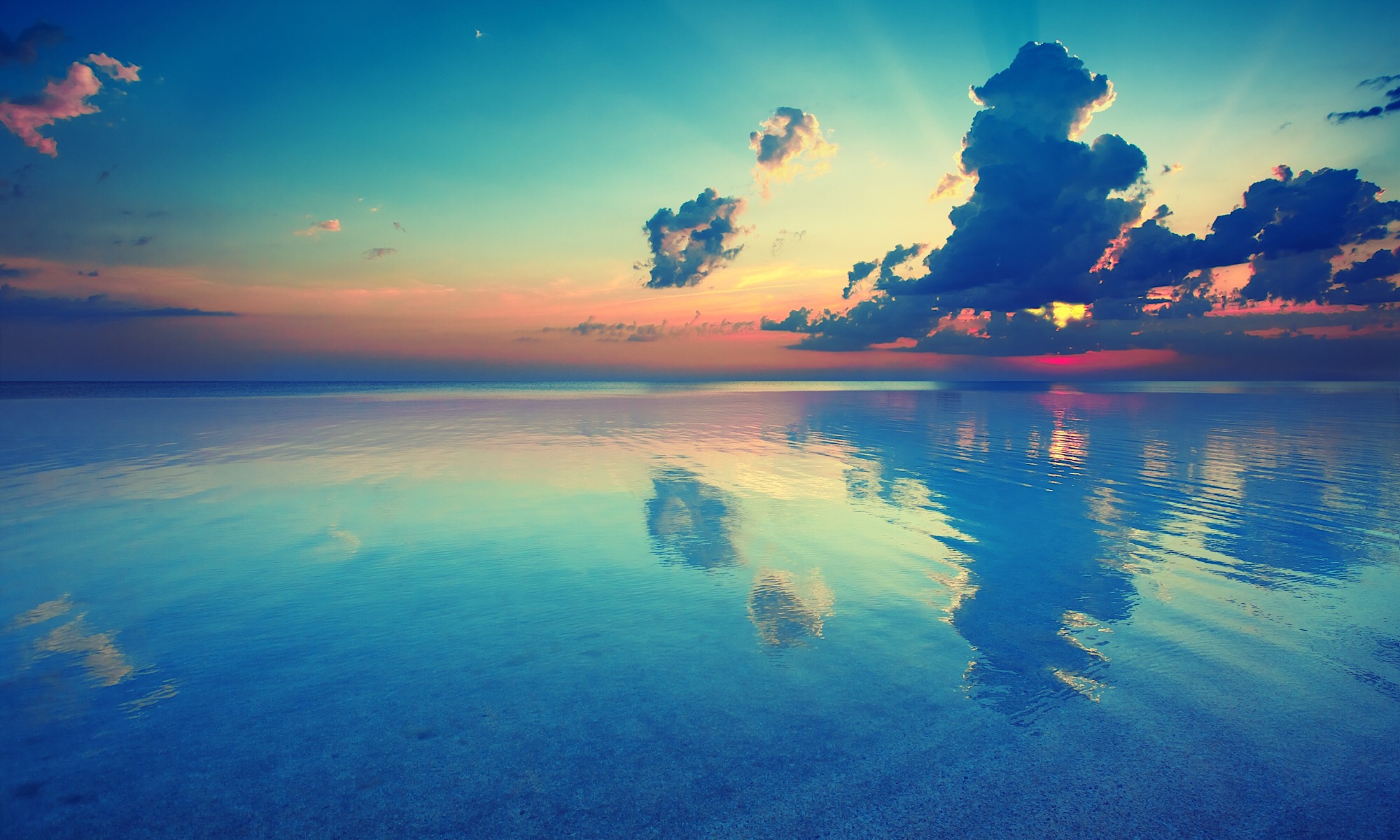 黄色とオレンジ色の夕日が青い海に反映した幻想的な美しい風景。