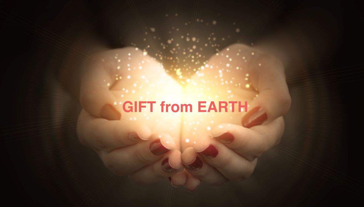 〝宝石は地球からの贈り物〟をイメージとした、神の手に沢山の粒子状の光をのせ、光の結集がハートに見える画像。